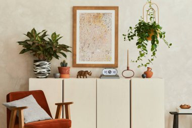 Yaratıcı ve modern bej oturma odası iç tasarımı poster çerçevesi, bej ahşap büfe, koltuk ve retro ilham verici kişisel aksesuarlar. Uzayı kopyala Şablon.