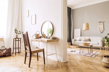 Ahşap masa, sehpa, kanepe, sandalye, çiçekler, ayna, makrome ve zarif aksesuarları olan açık alanların tasarım evlerinde modern konsept. Şık ve minimalist ev dekorasyonu. Şablon. 