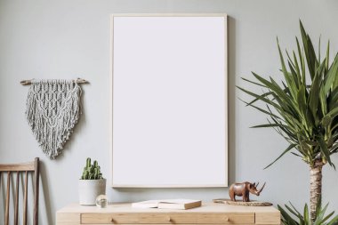 Poster çerçevesi, retro sandalye, ahşap masa, tropikal bitkiler, gri makrame ve zarif aksesuarlar ile sahte oturma odası şık ve boho kavramı. Modern iç tasarım. Güzel ev dekorasyonu. Şablon.