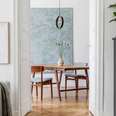 Poster çerçevesi, yeşil kanepe, ahşap mobilya, bitkiler ve aksesuarlarla süslenmiş şık ve yaratıcı oturma odası iç tasarımı. Beyaz duvarlar, parke zemin. Şablon.