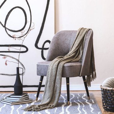 Şık gri koltuklu oturma odasının iç tasarımı, duvarında soyut resimler, vazoda çiçekler, yastık, ekose, sepet ve zarif kişisel aksesuarlar. Modern ev dekorasyonu. Şablon