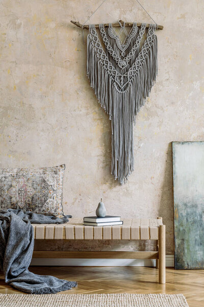 Stylish oriental living room interior with beige chaise longue, gray macrame, pillow, plaid, carpet, book and elegant personal accessories. Wabi sabi concept. Grunge wall. Design home decor. Template