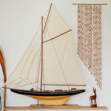 Oturma odasının iç tarafındaki ahşap rafta eski moda bir gemi. Ev dekoru. Şablon.