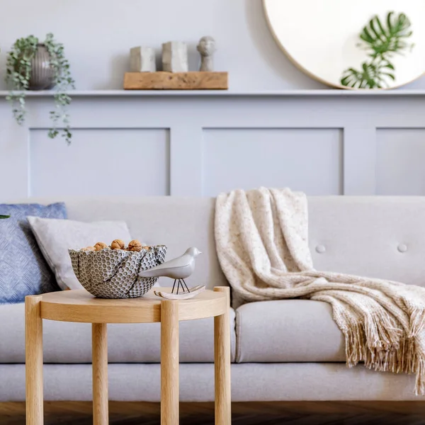 スタイリッシュなグレーのソファ コーヒーテーブル 熱帯植物 ミラー 現代の家庭の装飾で再生され エレガントなパーソナルアクセサリーと北欧のリビングルームのインテリアデザイン — ストック写真