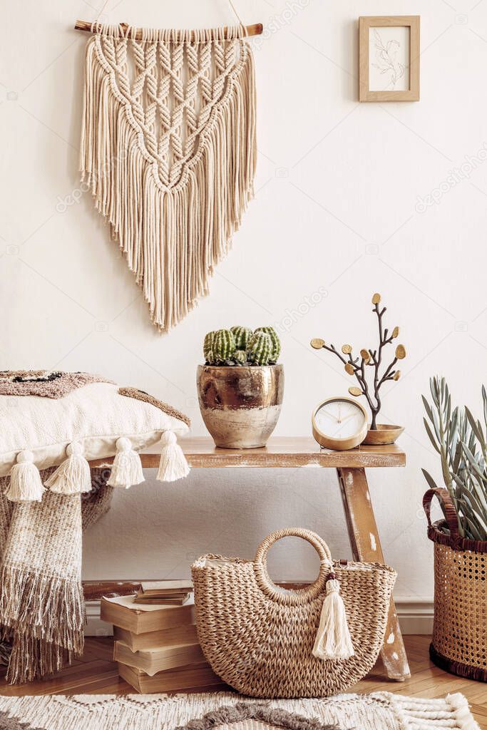 Stylish composition of living room interior with mock up frame, wooden bench, pillow, plaid, woman bag, books, cacti, macrame, plant, decortaion and elegant personal accessories in modern home decor.