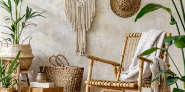 Oturma odasının iç kısmının şık ve çiçekli kompozisyonu içinde rattan koltuklar, tasarım kapları, dekorasyon, makrome ve şık ev dekorasyonu gibi pek çok tropikal bitki var..