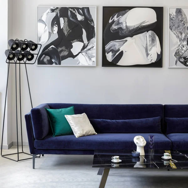 时尚而现代的客厅 内饰蓝色天鹅绒沙发 造型绘画 设计黑色灯具 混凝土地板 精致的室内装饰个人配饰 — 图库照片