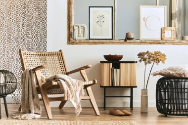 Şık rattan koltuklar, tasarım mobilyaları, kurutulmuş çiçekler, poster çerçeveleri, ahşap döşemeler, dekorasyon ve zarif kişisel aksesuarlarla eşsiz bir oturma odası. Modern ev. Şablon.