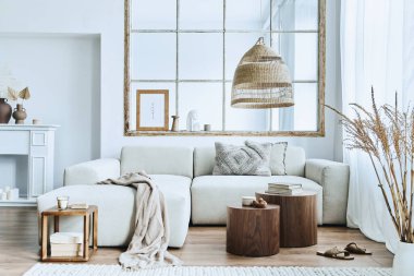 Modüler kanepe, mobilya, ahşap sehpa, rattan dekorasyonu, resim çerçevesi, yastık, kurumuş çiçekler ve modern ev dekorunda zarif aksesuarları olan şık bir oturma odası..