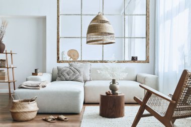 Modüler kanepe, mobilya, ahşap sehpa, rattan dekorasyonu, resim çerçevesi, yastık, kurumuş çiçekler ve modern ev dekorunda zarif aksesuarları olan şık bir oturma odası..