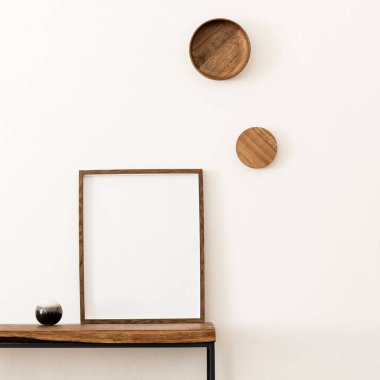 Yaratıcı ve şık bir oda. Poster çerçevesi, ahşap konsol ve aksesuarları var. Beyaz duvarlar. Minimalist bir kavram. Şablon