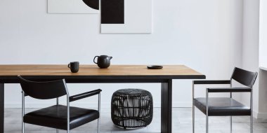 Tasarım ahşap aile masası, siyah sandalyeler, fincanlı çaydanlık, duvarda sanat resimleri ve modern ev dekorunda zarif aksesuarları olan şık bir yemek odası. Şablon.