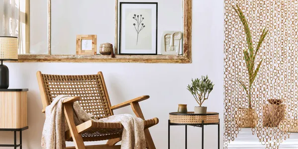 Unique living room interior with stylish rattan armchair,  design furniture, dried flowers, mock up poster frames,  wooden floor, decoration and elegant personal accessories. Modern home. Template.