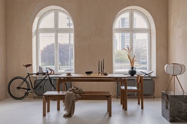 Ahşap yemek masası, koltuklar ve güzel kişisel aksesuarları olan geniş bir yemek odasının şık iç tasarımı. Modern ev dekorasyonu. Yapı duvarı. Kırsal minimalitik ilham. Şablon