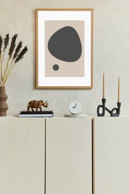 Şık ve modern bej oturma odası iç kompozisyonu poster çerçevesi, bej ahşap büfe ve Boho 'dan esinlenilmiş aksesuarlar. Şablon