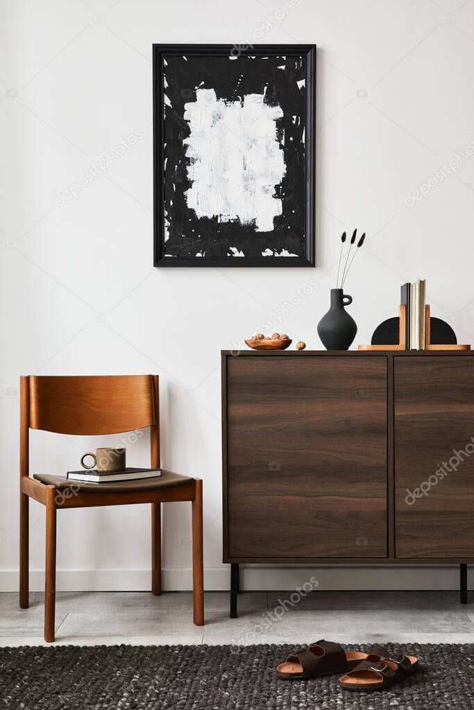 Stylish living room interior composition with mock up poster frame, brown wooden commode, armchair and small home decorations. White wall. Copy space. Template.