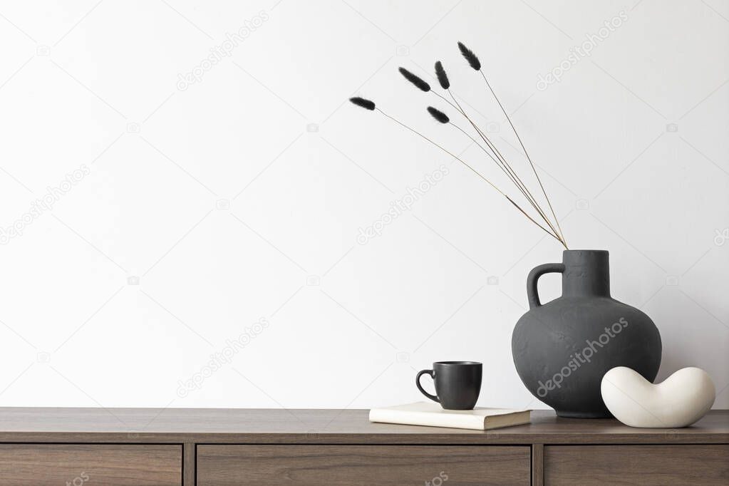 Creative minimalistic composition with white wall and stylish small personal accessories on wooden commode. Copy space. Template.