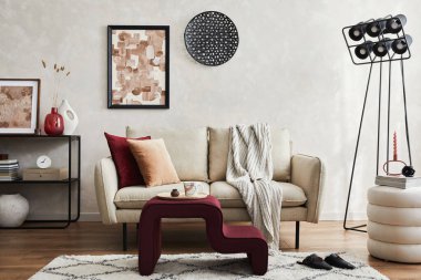 Bej kanepe, siyah konsol, kahve masası, puf, poster çerçevesi ve yaratıcı tasarım kişisel aksesuarları olan şık bir oturma odası kompozisyonu. Uzayı kopyala Şablon