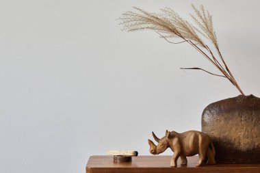 Minimalist composition of living room interior with wooden commode, vintage vase and personal accessories. Copy space. Wallpaper. Template.