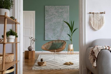 Crey Scandi kanepesi, rattan koltuğu, bitkiler, halı ve güzel boho aksesuarlarıyla yaratıcı bir iç dizayn. Okaliptüs duvarları ve parke zemin. 