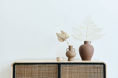 Modern İskandinav ev dekorasyonu ahşap klozet, seramik vazolarda kurutulmuş yapraklar ve şık ev dekorunda kişisel aksesuarlar. Şablon. Uzayı kopyala Beyaz duvarlar.
