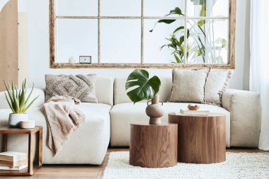 Modüler bej kanepesi, ahşap sehpası, bitkileri, yastıkları, ekoseli, nötr oda bölücüsü, dekorasyonu ve zarif aksesuarları olan oturma odasının iç tasarımı. Modern ev dekorasyonu. Şablon.