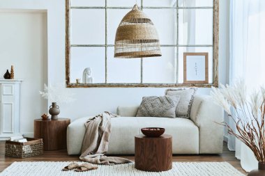 Modüler kanepe, mobilya, ahşap sehpa, rattan dekorasyonu, resim çerçevesi, yastık, kurumuş çiçekler ve modern ev dekorunda zarif aksesuarları olan şık bir oturma odası..