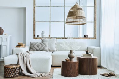 Modüler kanepe, mobilya, ahşap sehpa, rattan dekorasyonu, resim çerçevesi, yastık, kurumuş çiçekler ve modern ev dekorunda zarif aksesuarları olan şık bir oturma odası..