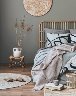 Ahşap yatak odası, mobilya, halı decro, tabure, rattan dekorasyon, vazolar ve zarif aksesuarlarla dekore edilmiş şık bir kompozisyon. Güzel çarşaflar, battaniye ve yastıklar. Konforlu ev dekorasyonu. 