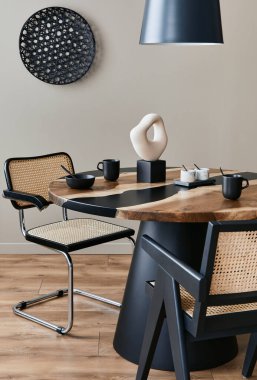 Modern yemek odasının iç tasarımı şık sandalyeler, ahşap masa, siyah süs lambası, seramik kap, fincanlı çaydanlık. Süslü ev dekorasyonu. Şablon.