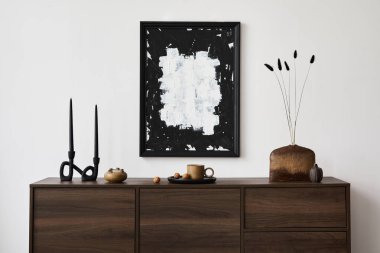 Modern oturma odası iç tasarımının yaratıcı kompozisyonu poster çerçevesi, kahverengi tuvalet, vazolar, şamdanlar ve kişisel aksesuarlarla. Beyaz duvar. Uzayı kopyala Şablon.