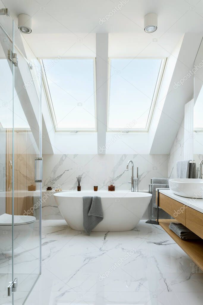 Stylish bathroom interior design with marble panels. Bathtub, towels and other personal bathroom accessories. Modern glamour interior concept. Roof window. Template