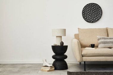 Zarif oturma odası iç tasarımı bej kanepe, yaratıcı ahşap yan masa, lamba ve modern ev aksesuarları. Duvar kağıdı. Uzayı kopyala Şablon.  