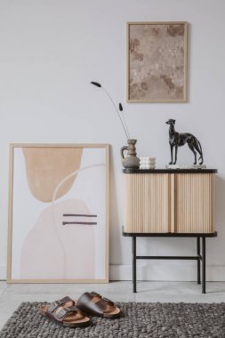 Yaratıcı oturma odası iç tasarımı. Duvardaki soyut resim ve poster çerçevesi. Ahşap dolapta şık aksesuarlar var. Şablon. Boşluğu kopyala