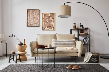 Modern oturma odasının yaratıcı kompozisyonu poster çerçeveleri, bej kanepe, yan masa ve metal raflarda şık küçük kişisel aksesuarlar. Uzayı kopyala Şablon. 