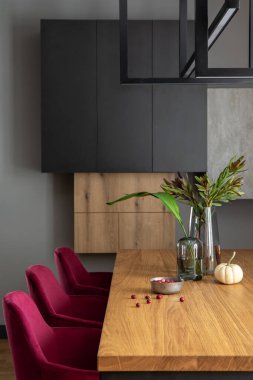 Şık yemek odası iç tasarımı kadife sandalyeler, ahşap masa, lambalar, baca ve güzel kişisel aksesuarlarla süslenmiş şık bir kompozisyon. Modern ev dekorasyonu. Şablon.
