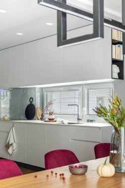 Şık yemek odası iç tasarımı kadife sandalyeler, ahşap masa, lambalar, baca ve güzel kişisel aksesuarlarla süslenmiş şık bir kompozisyon. Modern ev dekorasyonu. Şablon.