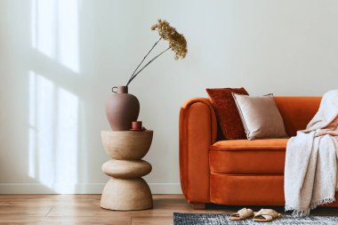 Tasarım kadife kanepe, yan masa, yastık, dekorasyon, vazoda kurumuş çiçek ve modern ev dekorunda zarif aksesuarlarla dekore edilmiş şık bir oturma odası konsepti. Uzayı kopyala Şablon.