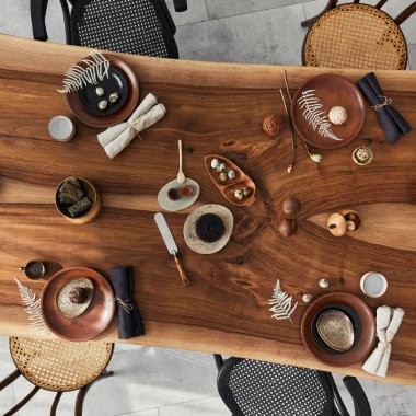 Ahşap ceviz masası, retro sandalyeler, sofra takımı, tabaklar, masa örtüsü, çaydanlık, yemek, dekorasyon ve zarif aksesuarları olan şık bir iç dizayn. Beton zemin. Şablon. Üst görünüm.