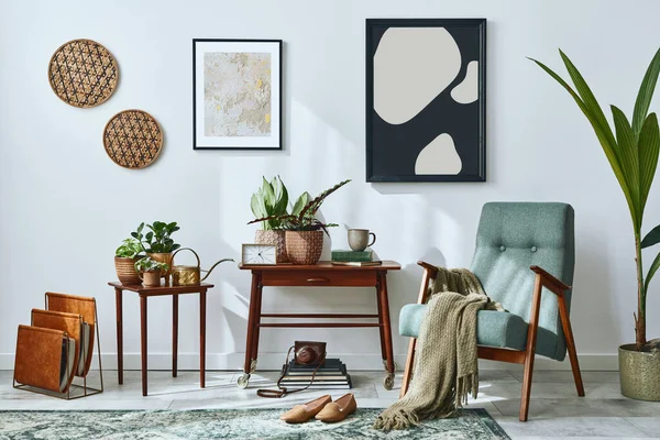 Interior design of retro living room with stylish vintage armchair, shelf, house plants, cacti, decoration, carpet and two mock up poster frames on the white wall. Botany home decor. Template.