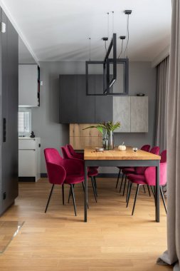 Kadife sandalyeli şık bir iç dizayn ahşap masa, lambalar ve güzel kişisel aksesuarlar. Açık alan. Beton duvarlar. Modern ev dekorasyonu. Şablon.
