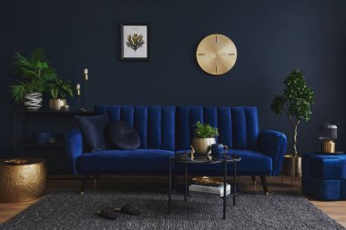 Modern oturma odasının iç tasarımı göz kamaştırıcı mavi kanepe, metal raf, sehpa, puf ve zarif ev aksesuarları. Koyu mavi duvar. Ev sahnesi. Şablon. Boşluğu kopyala