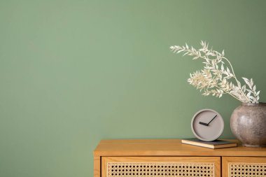 İçinde rattan klozet, modern ev dekorasyonu ve kişisel aksesuarlar olan yaratıcı yatak odası kompozisyonu. Okaliptüs yeşili duvar. Şablon. Boşluğu kopyala.