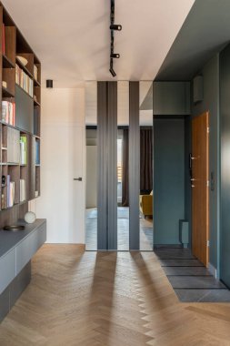 Televizyon, kitaplık ve çekmeceli tahta herringbone parke Lamella duvarlı yaratıcı ve modern oturma odası iç tasarımı. Şablon.