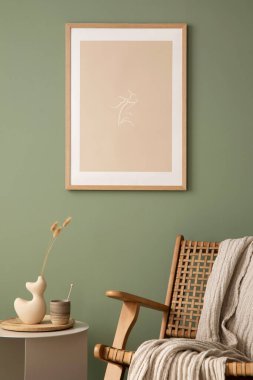 Stylish living room interior design with mock up poster frames, rattan armchair, coffe table, beige carpet and creative home accessories. Sage green wall. Template. 