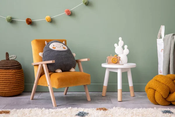 Creative composition of stylish and cozy child room interior design with greeen wall, plush toys, orange armchair, furniture and accessories. Stool with accessories. Panels floor. Template.