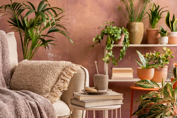 Stylish composition of creative spacious living room interior with plants, beige sofa, coffee table and stylish accessories. Botanical space of a cozy room. Brown walls . Template.