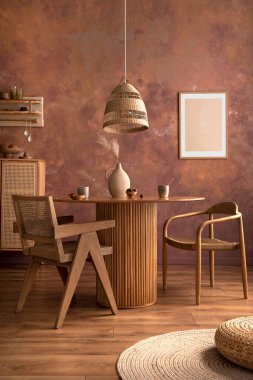 Poster modelli şık bir boho klasik yemek odası iç mimarisi. Rattal sandalyeli yuvarlak masa, kurumuş çiçekli vazo. Kahverengi duvar ve rattan lamba. Posteri düzenle. Şablon. 