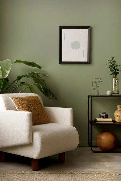 Stylish composition of living room interior with mock up, green wall, white armchair with brown pillow. Brown consola with accessories. Mock up poster. Template.