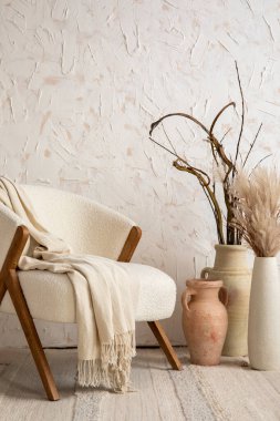 The stylish composition a living room interior with white armchair, vase with dried flowers and personal accessories. Home decor. Template. 